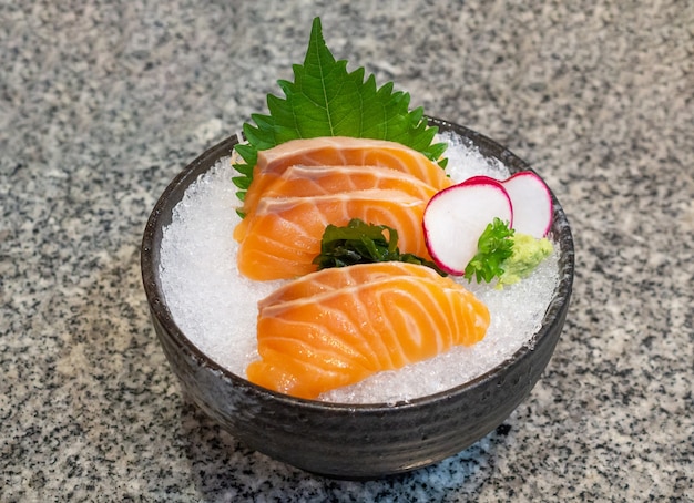 Sashimi z łososia na lodzie w czarnej misce japońskie jedzenie