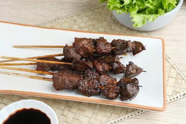 Satay lub Satay mięsne kambing podawane z plastrami pomidorów chili z czerwonej cebuli z sosem sojowym