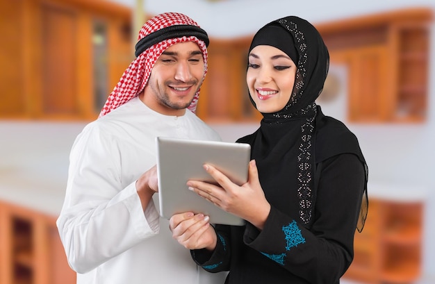 Saudyjska szczęśliwa para przeglądająca z cyfrowym tabletem