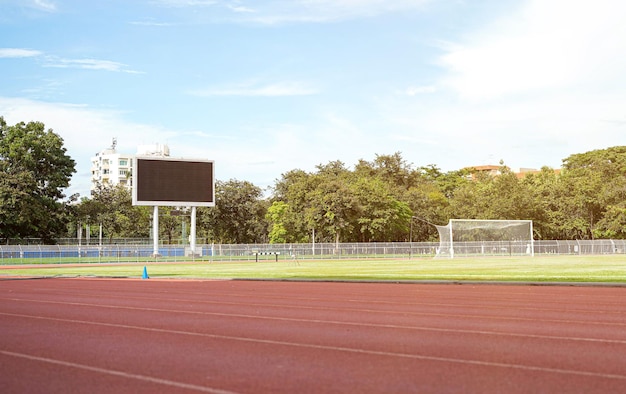 Scena boiska piłkarskiego z tablicą wyników i jasnym błękitnym niebem