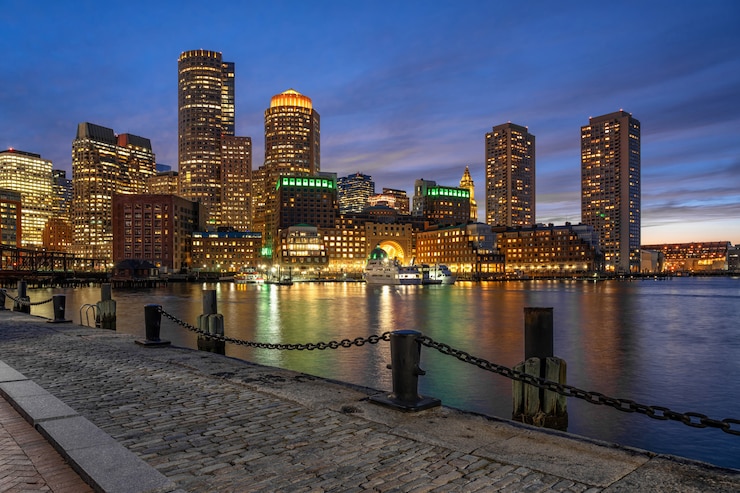 Zdjęcie scena boston skyline z fan pier w fantastycznym czasie zmierzchu z gładką wodą rzeki