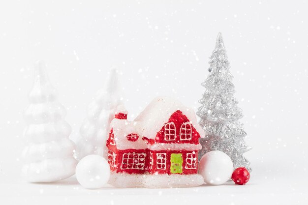 Scena bożonarodzeniowa miniaturowa wioska daczy Boże Narodzenie małe czerwone domy jelenie i ośnieżone jodły