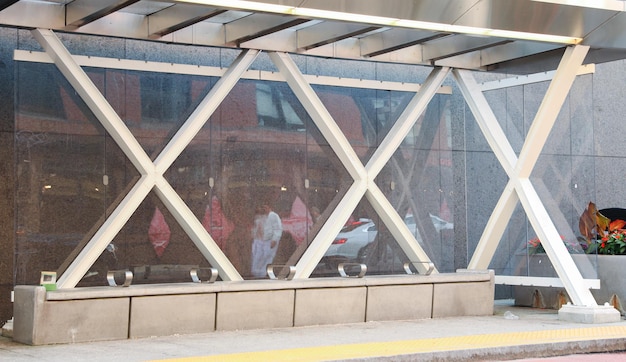 Scena na dworcu autobusowym z różnymi pasażerami czekającymi pod stalowym baldachimem Światło słoneczne przenika przez cre