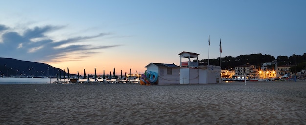 Scena na plaży z chatką na plaży i tabliczką z napisem „chata na plaży”.