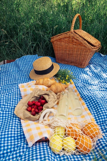 Scena piknikowa rogaliki truskawki lemoniada na niebieskim kocu