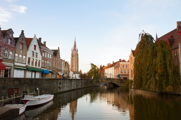 Scena starego miasta z kanałem i wieżą Vrouwekerk, Belgia