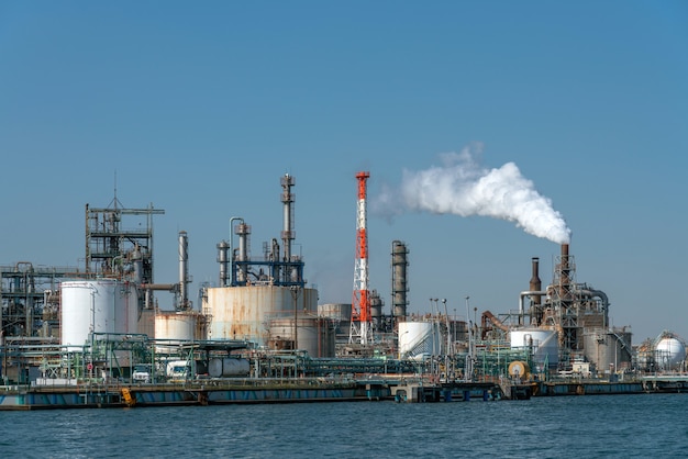 Scena Strefy Przemysłowej Rafinerii Ropy Naftowej Nad Rzeką W Godzinach Pracy, Która Ma Dym Parowy