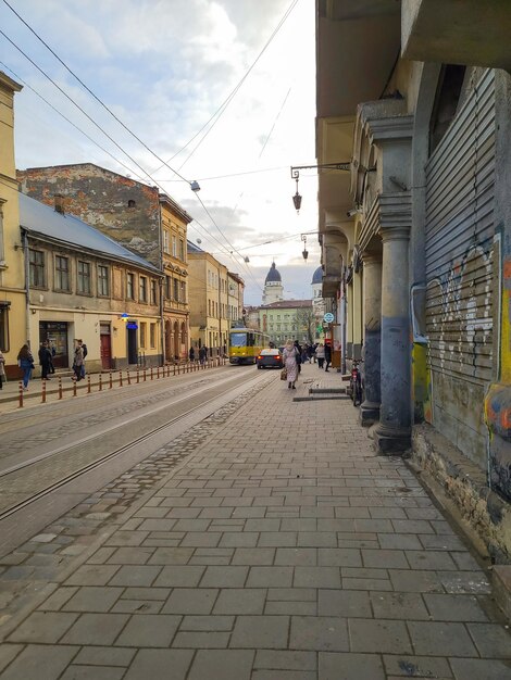 Scena Uliczna Z żółtym Tramwajem Po Lewej Stronie I Budynkiem Z Napisem „tramwaj”.