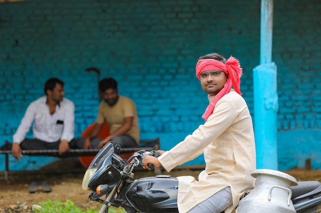 Scena wiejska: indyjski mleczarz rozdaje mleko na rowerze