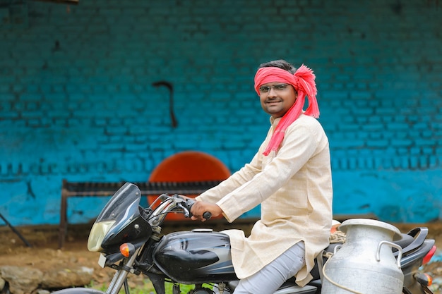 Scena wiejska: indyjski mleczarz rozdaje mleko na rowerze