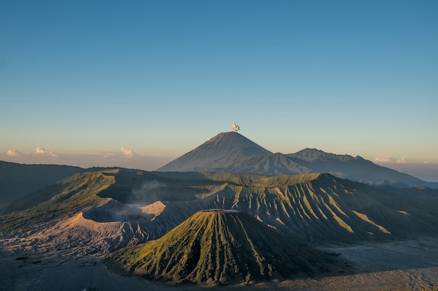 Zdjęcie sceneria wulkan semeru wypluwał dym i krater wulkanu bromo, który wciąż wybuchał w indonezji