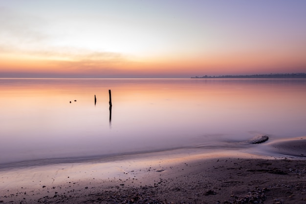 Zdjęcie scenic ocean zachód słońca nad spokojną powierzchnią wody