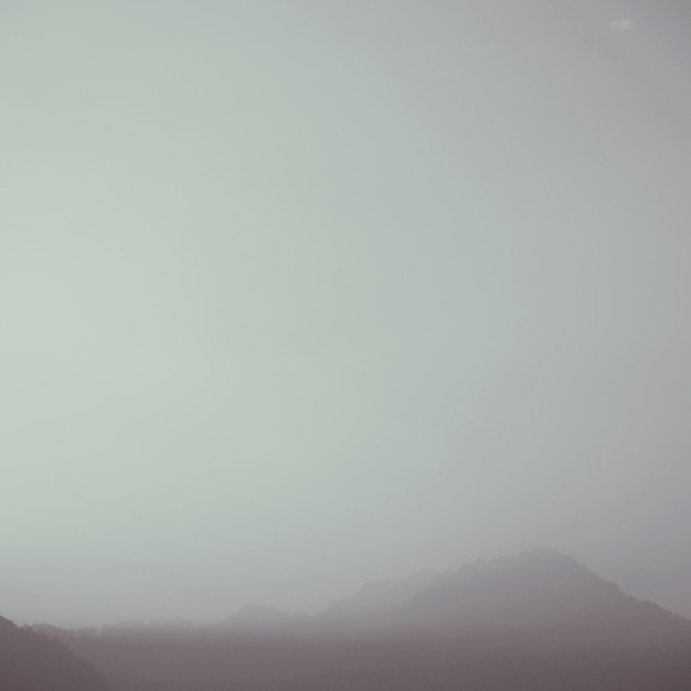 Zdjęcie sceniczny widok gór na tle nieba w mglistą pogodę