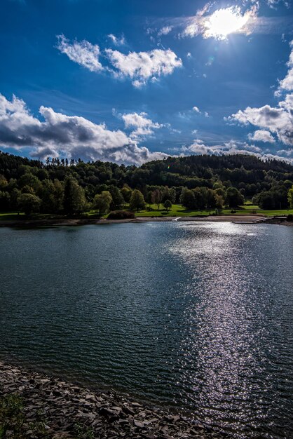 Zdjęcie sceniczny widok jeziora przez drzewa na tle nieba