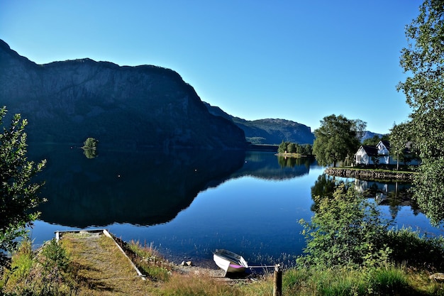 Sceniczny widok jeziora przez góry na tle niebieskiego nieba