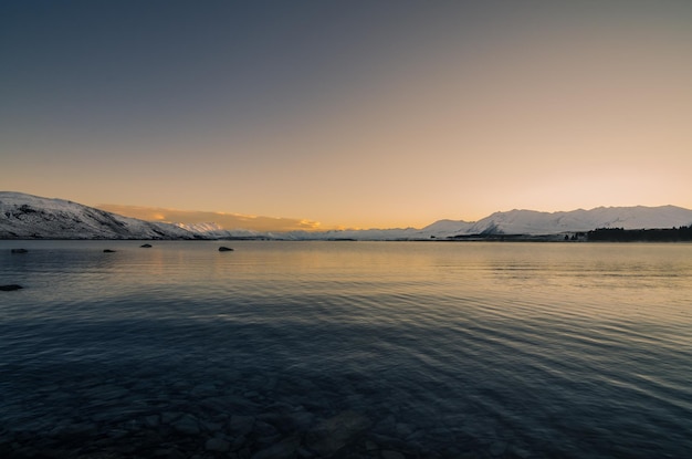 Sceniczny widok jeziora tekapo na tle nieba o świcie