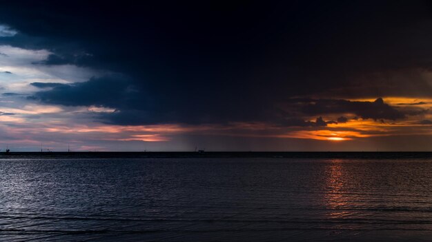 Zdjęcie sceniczny widok morza na tle dramatycznego nieba podczas zachodu słońca