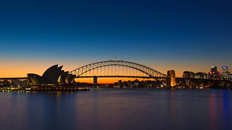 Zdjęcie sceniczny widok mostu sydney harbour na jasnym niebie podczas zachodu słońca