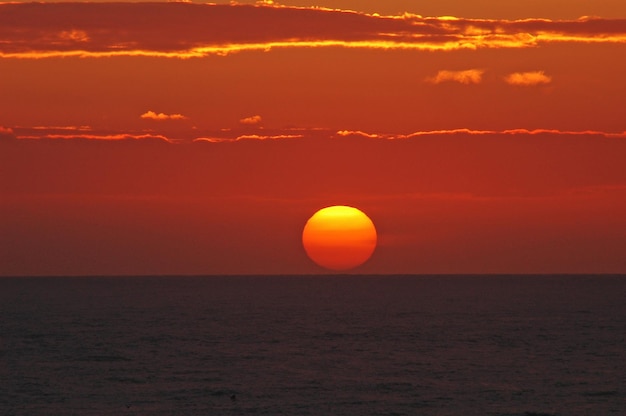 Sceniczny widok na morze na tle romantycznego nieba przy zachodzie słońca