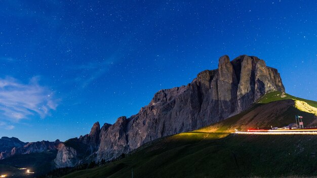 Zdjęcie sceniczny widok oświetlonych śladów światła na drodze przez górę na tle nieba