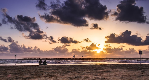 Sceniczny widok plaży na chmurnym niebie podczas zachodu słońca