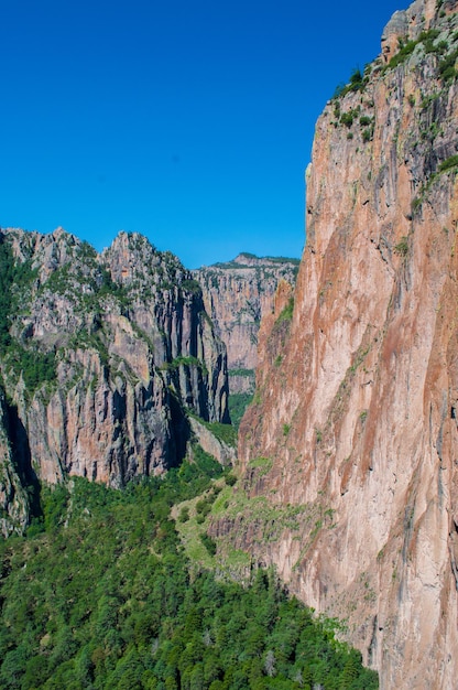 Sceniczny widok skalistych gór na jasnym niebie