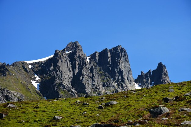 Zdjęcie sceniczny widok skalistych gór na tle jasnego niebieskiego nieba