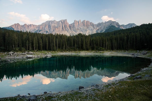 Sceniczny widok spokojnego jeziora z odbiciem drzew i gór w zimie