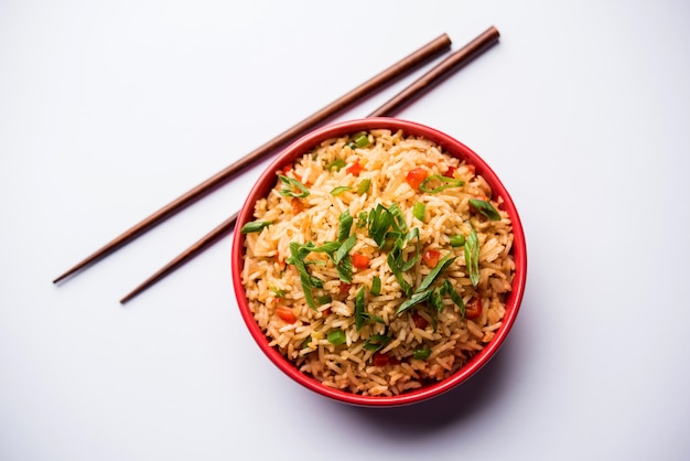 Schezwan Fried Rice Masala to popularne indochińskie jedzenie podawane na talerzu lub misce z pałeczkami