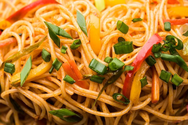 Schezwan Noodles lub warzywny makaron Hakka lub chow mein to popularne przepisy indochińskie, podawane w misce lub talerzu z drewnianymi pałeczkami. selektywne skupienie