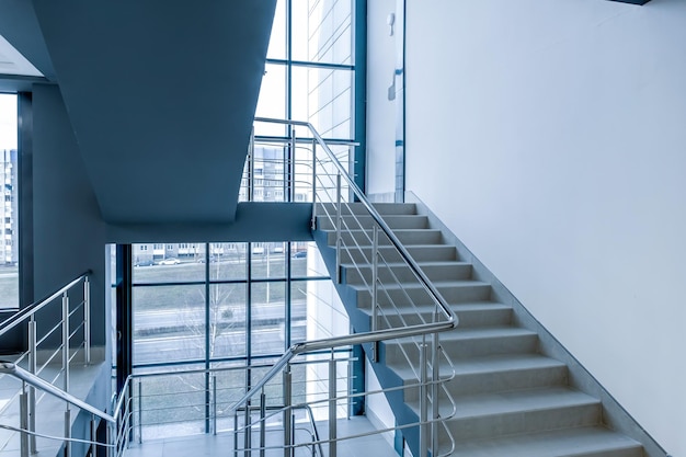 Schody awaryjne i ewakuacyjne schody w górnej drabinie w nowym budynku biurowym w niebieskim kolorze