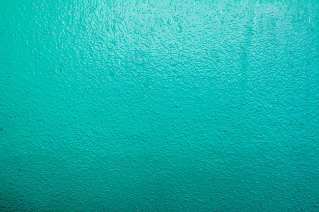 Ściana pomalowana na kolor niebieski. Tekstura jasnozielone ściany betonowe. Abstrakcyjne tło.