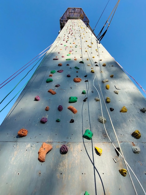 Ściana wspinaczkowa sportowa w perspektywie z różnymi hakami wiszącymi liną asekuracyjną Widok od dołu