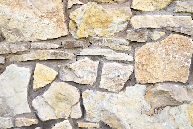 Ściana zbudowana z chropowatych kamieni piaskowca różnej wielkości, mocowana cementem
