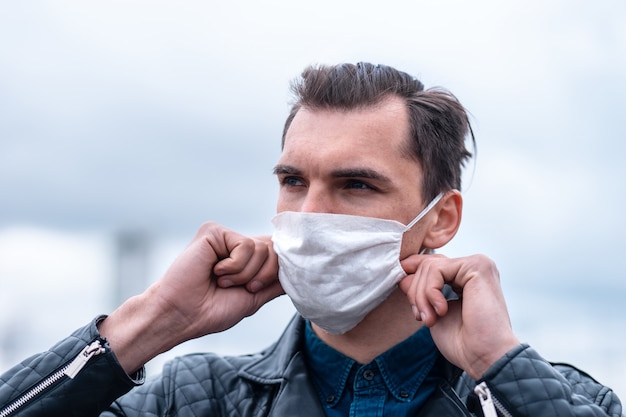 Ścieśniać. młody mężczyzna, zakładając maskę ochronną. pojęcie ochrony zdrowia