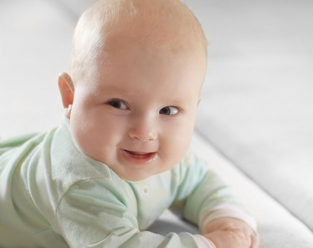 Ścieśniać. Portret Całkiem Małego Dziecka Na Niewyraźne Tło. Zdjęcie Z Miejsca Na Kopię.