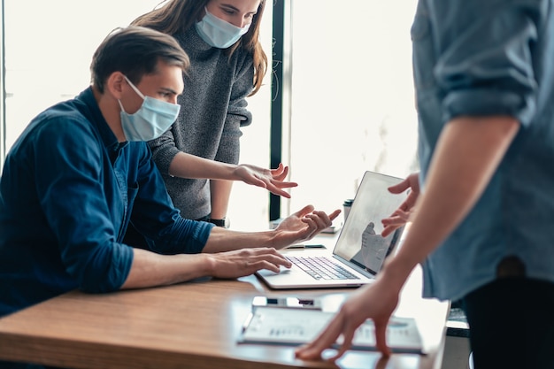 Ścieśniać. pracownicy w maskach ochronnych omawiający informacje online