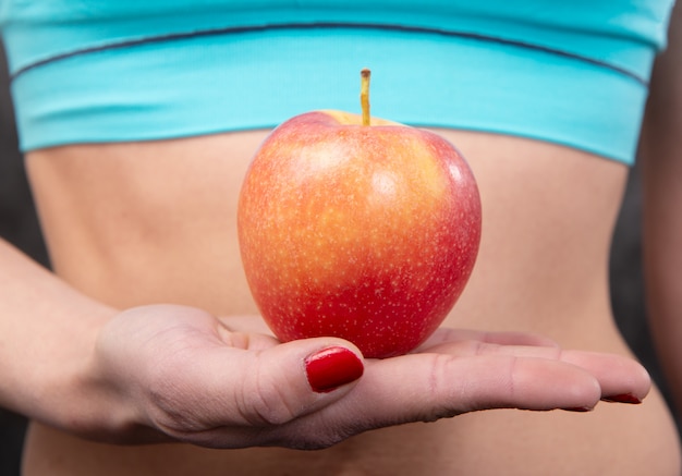 Ścieśniać. szczupła figura talia brzuch młoda kobieta dziewczyna trzyma soczyste jabłko