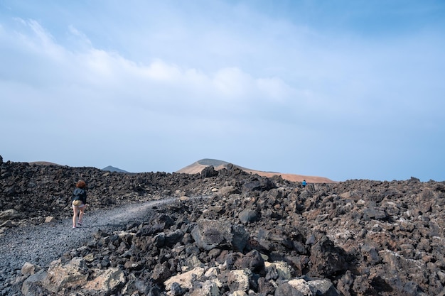 Ścieżka między lawą z widokiem na wulkan Caldera Blanca Timanfaya Wyspy Kanaryjskie Lanzarote Hiszpania