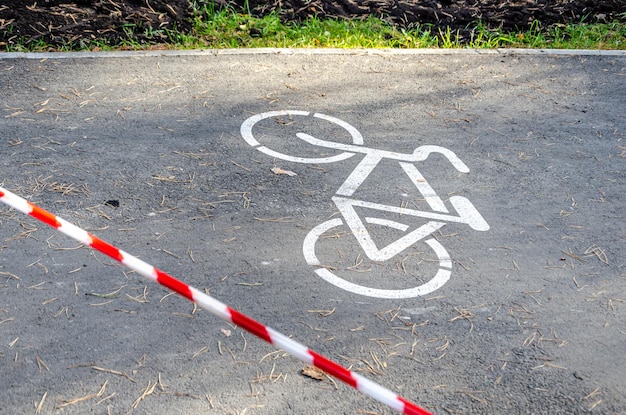 Ścieżka rowerowa ogrodzona czerwono-białą taśmą ochronną Ogrodzony teren w parku zakaz poruszania się