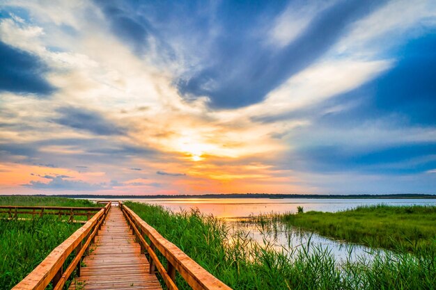 Zdjęcie Ścieżka spacerowa w jeziorze promenada drewniany most dla ścieżki przyrody piękny zachód słońca