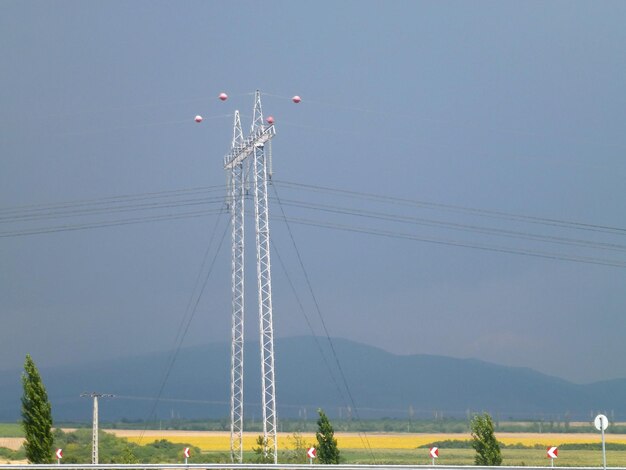 Ścieżki elektryczne na tle pola pszenicy i odległej góry