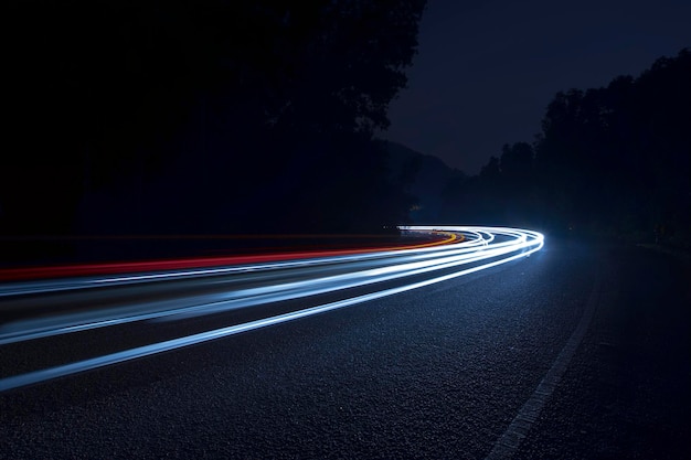 Ścieżki światła na drodze na tle nocnego nieba