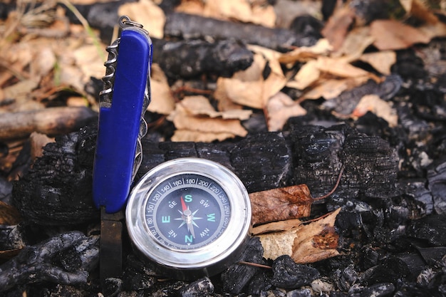 Scyzoryk i kompas na węglach zgaszony ognisko piknik rekreacja i przygody w dziczy