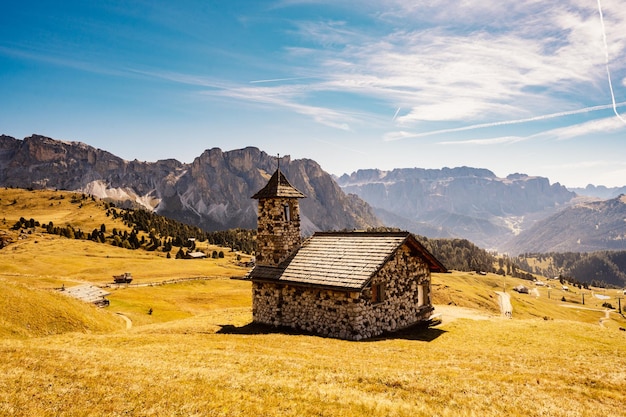 Seceda Majestatyczny pejzaż alpejskiej czerwieni jesiennej przyrody Seceda Cudowne piesze wędrówki przyroda w dolomitach Drewniane domki w Dolomitach Pasmo górskie Odle Val Gardena Majestatyczny szczyt Furchetta