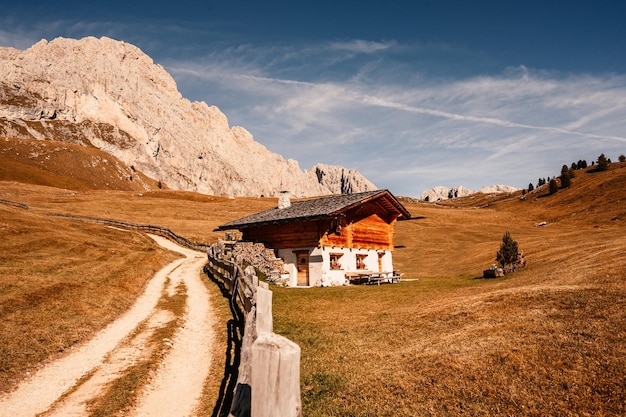 Seceda Majestatyczny pejzaż alpejskiej czerwonej jesiennej przyrody Seceda Wspaniała turystyczna sceneria przyrody w dolomitach Drewniane domki w Dolomitach Pasmo górskie Odle Val Gardena Majestatyczny szczyt Furchetta