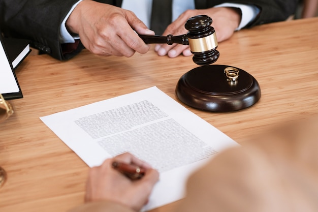 Sędzia młotek decydujący się na podpisywanie dokumentów rozwodowych małżeństwa. prawnik