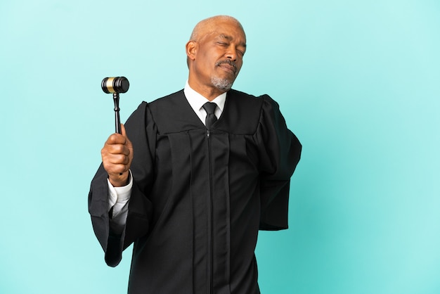Sędzia starszy mężczyzna odizolowany na niebieskim tle cierpiący na ból pleców za wysiłek