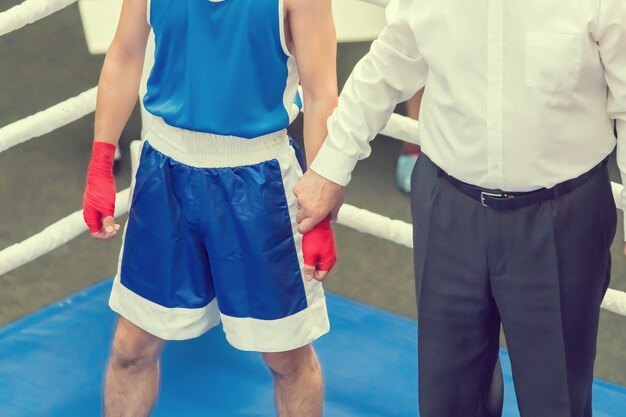 Sędzia trzyma boksera za rękę na ringu