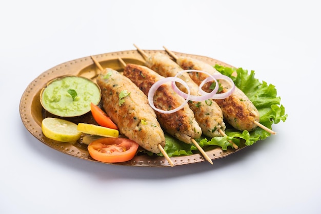 Seekh Kabab z mielonym kurczakiem lub keemą z baraniny, podawany z zielonym chutney i surówką